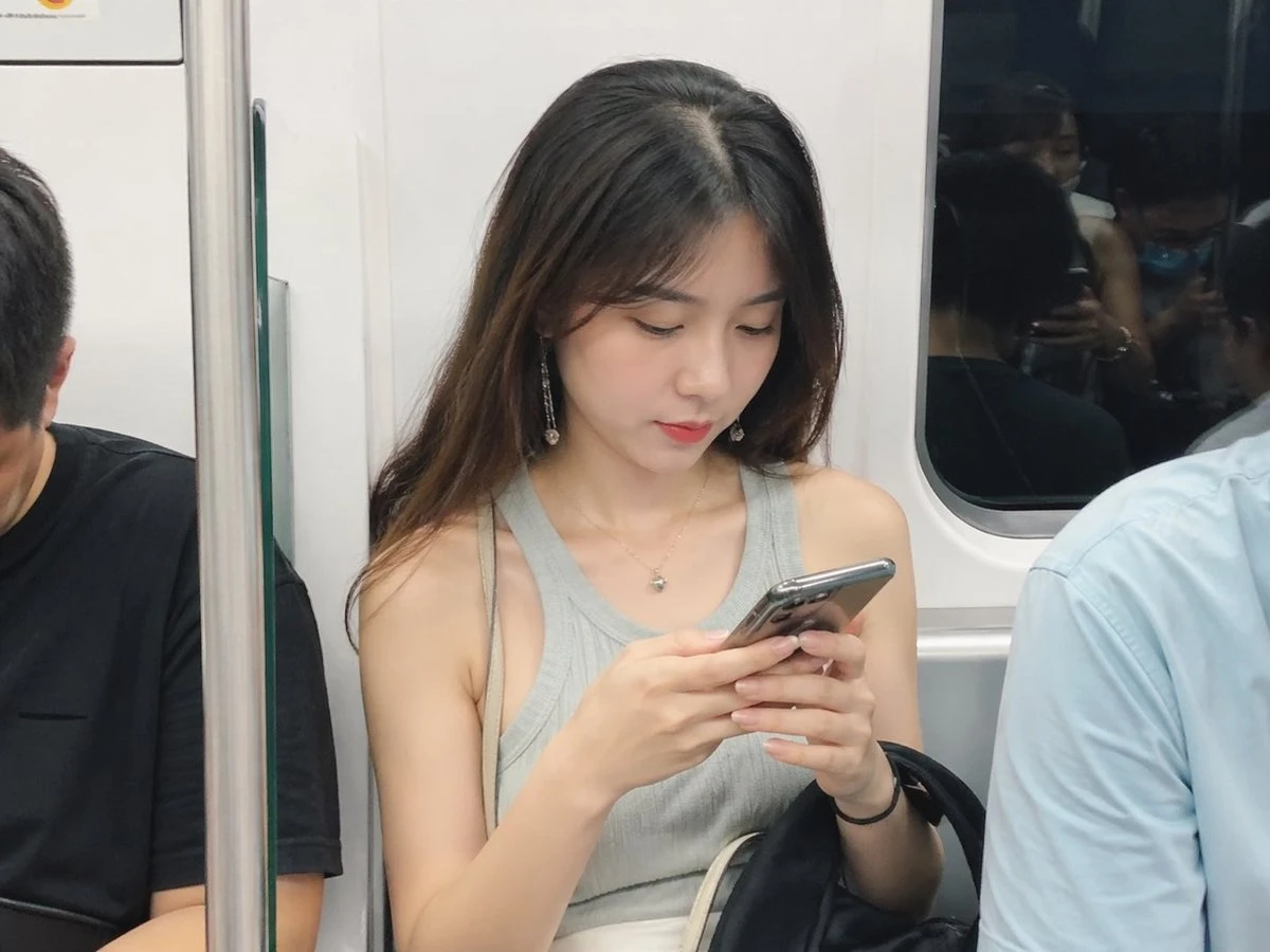 地铁上低头看手机的美丽女人